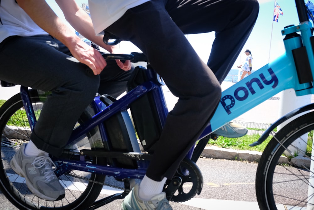 a man riding a blue bike down a street