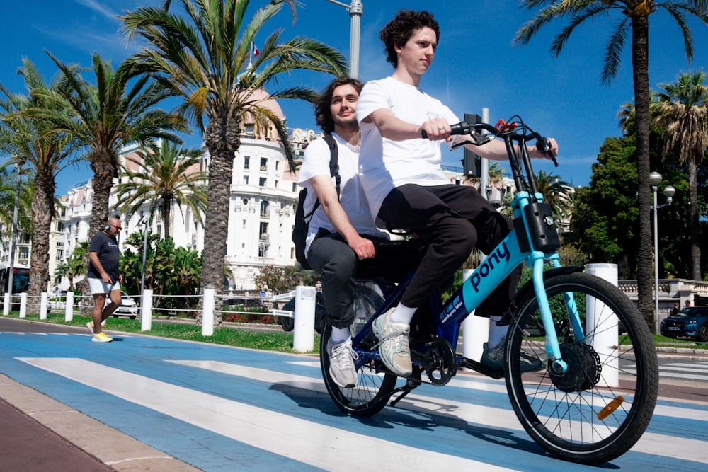 a man and a woman riding a bike on a city street