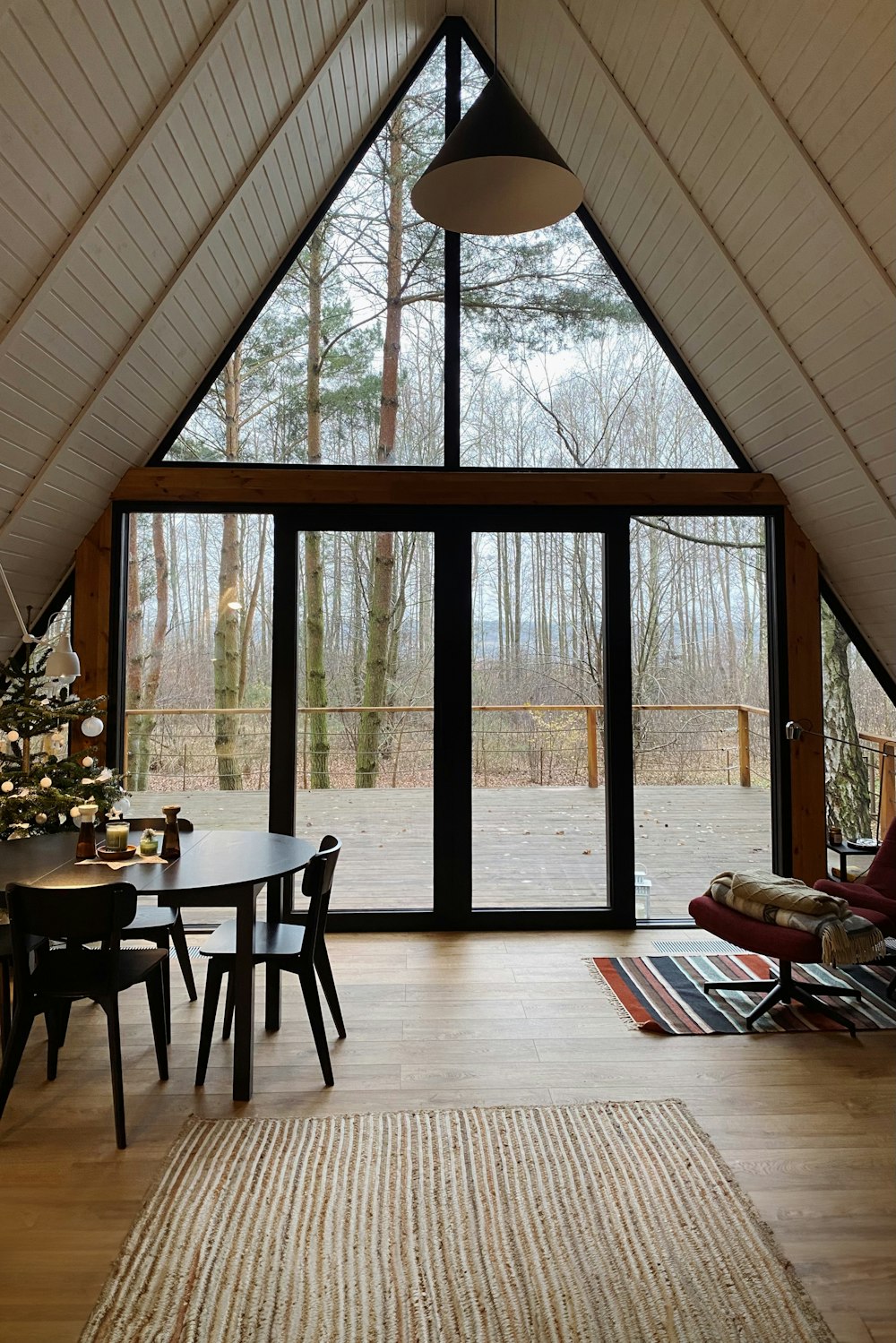 a room with a table, chairs, and a large window