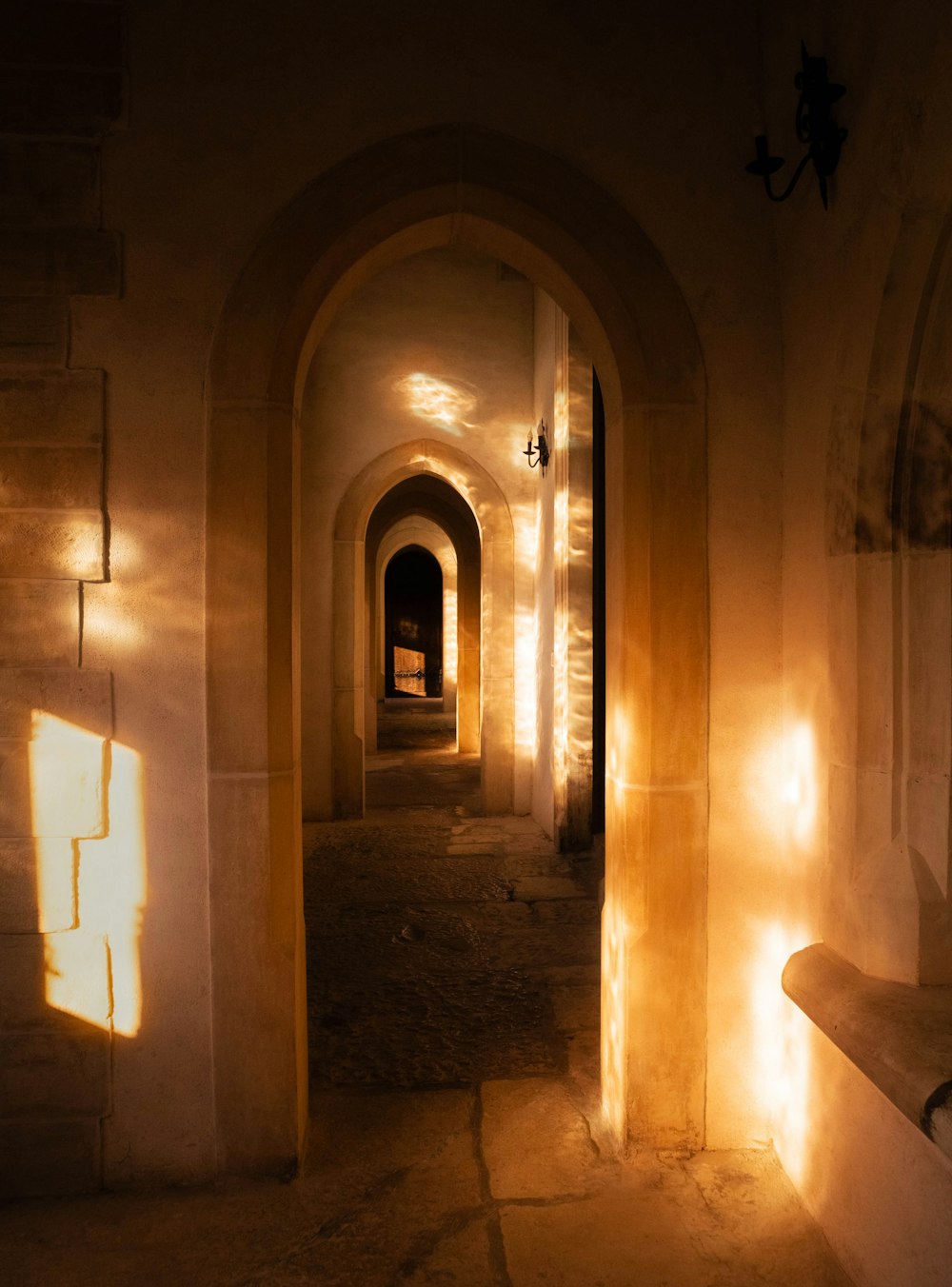 a dimly lit hallway with a bench in the middle