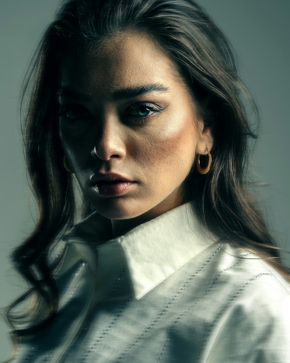 a woman with blue eyes and a white shirt