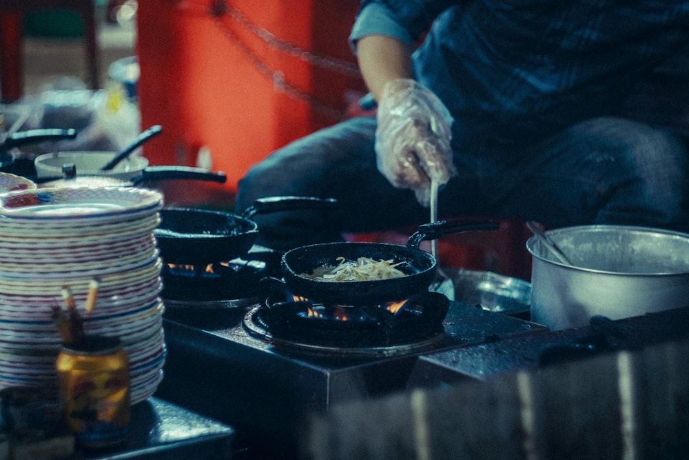 a man cooking food on top of a stove