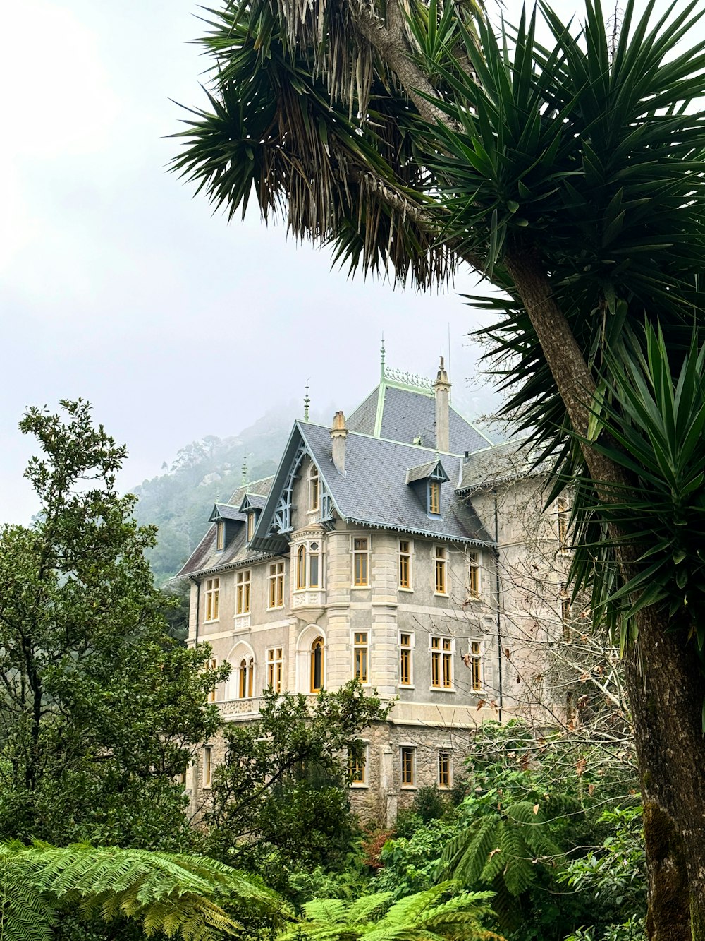 a large building with a blue roof surrounded by trees