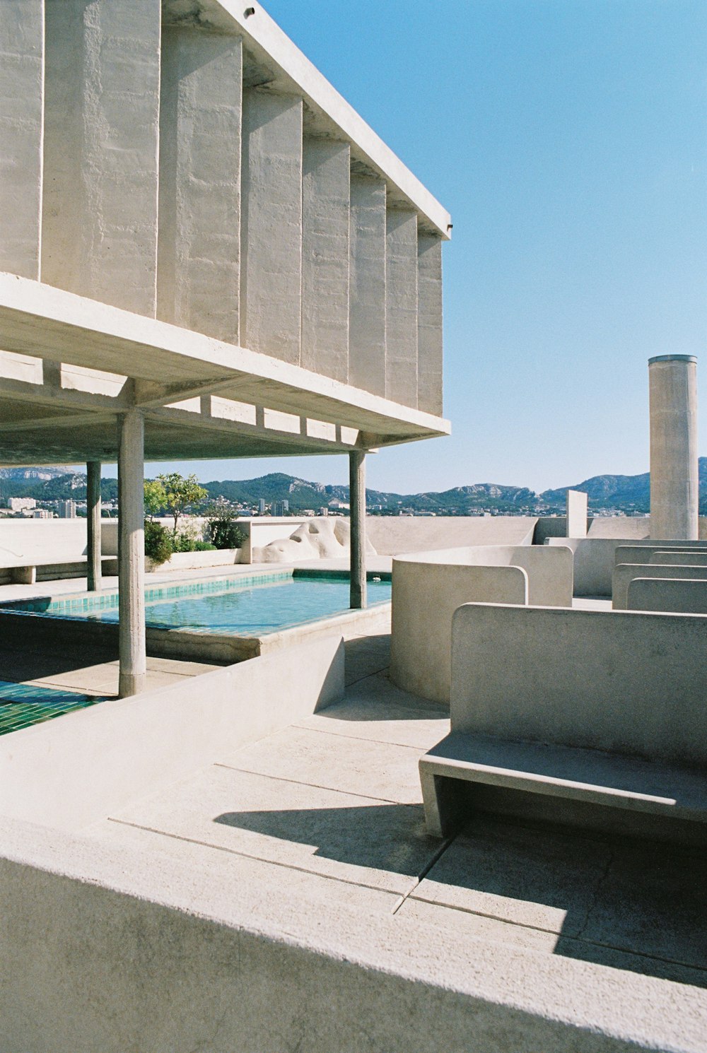 a concrete bench sitting next to a swimming pool