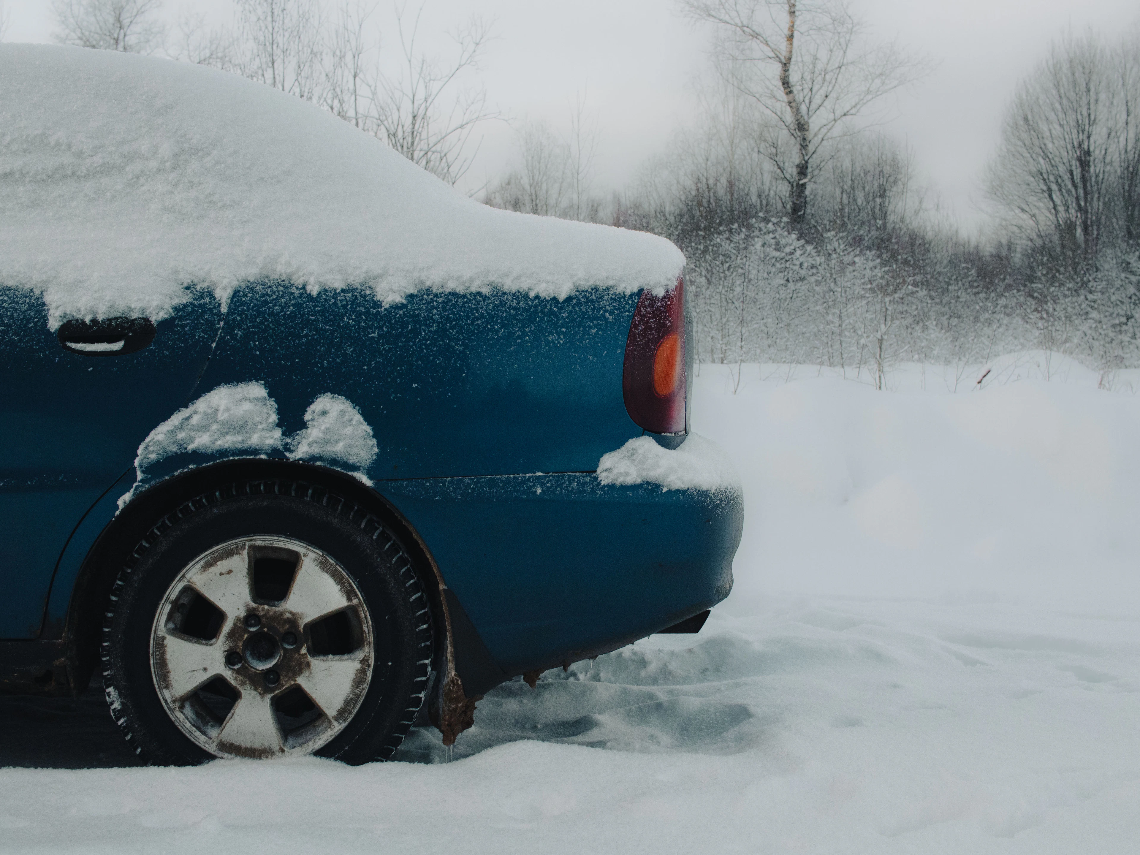Blue car parked in fresh snow