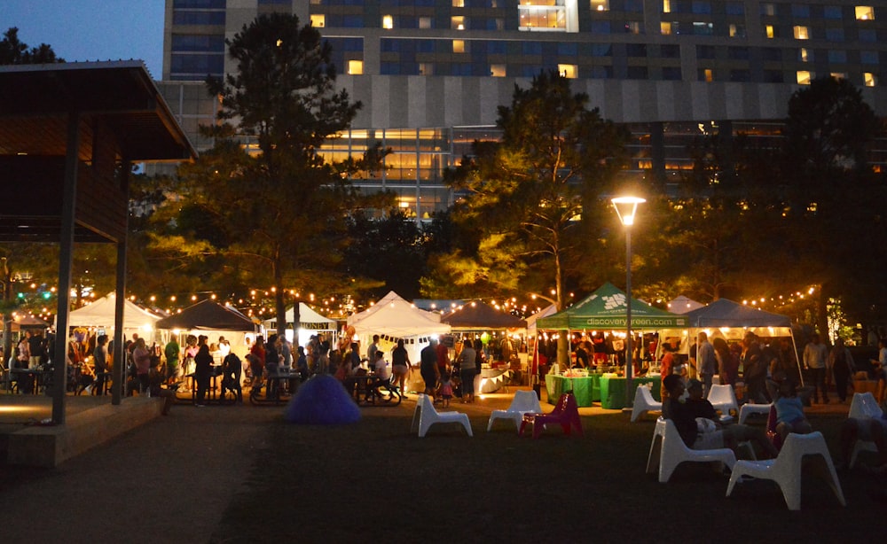 a group of people sitting around tables under tents