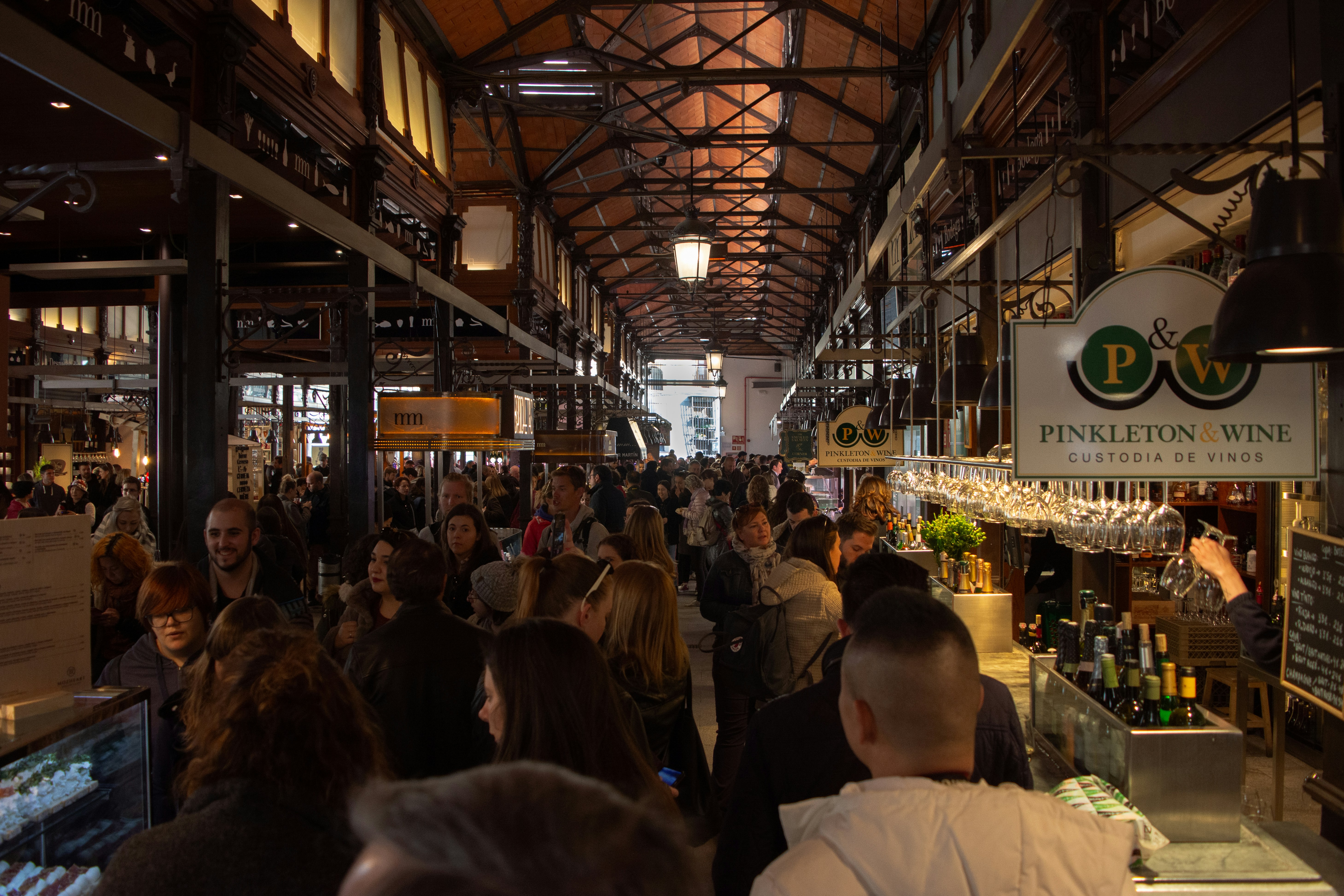 a large group of people walking through a store