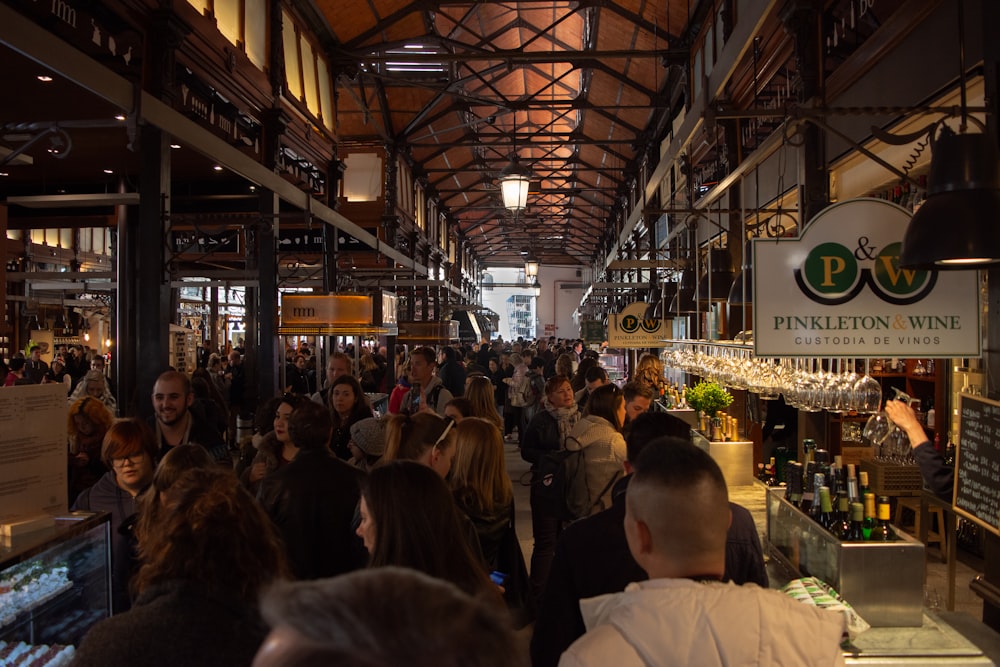 a large group of people walking through a store