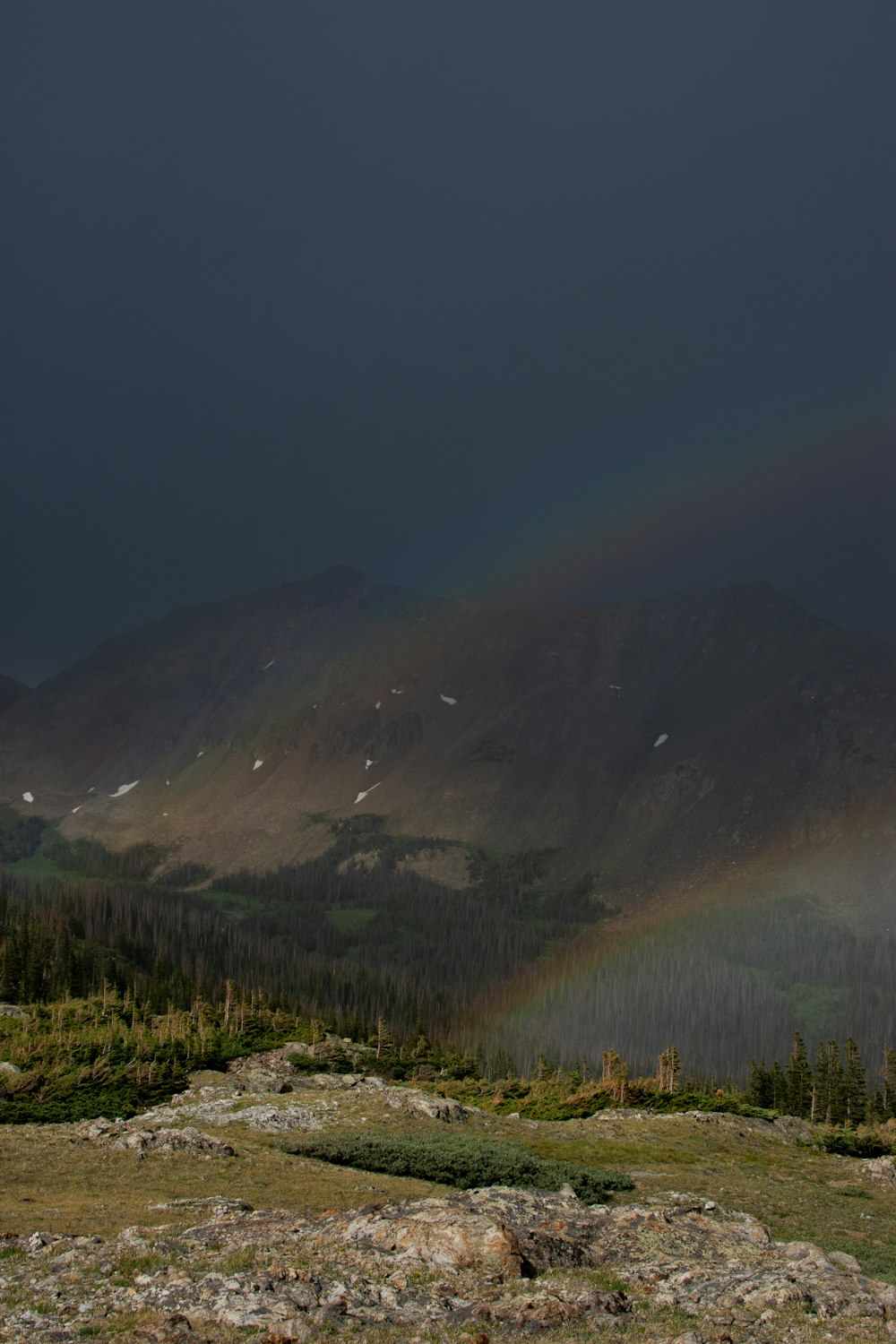 山脈の向こうの空に架かる虹