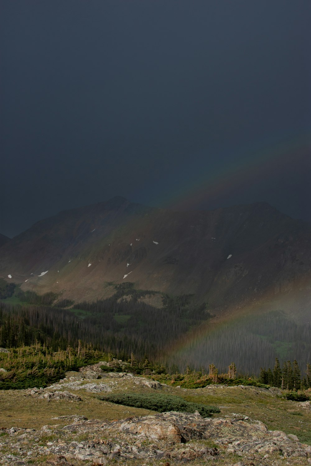 a rainbow in the sky over a mountain range