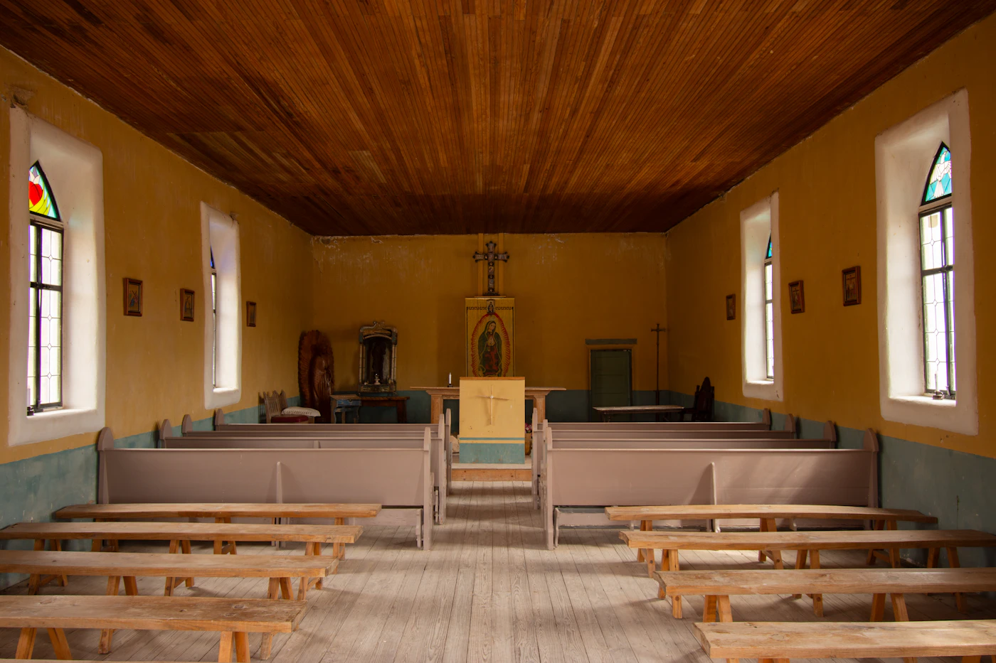 The chapel, with plain pews under a wooden ceiling