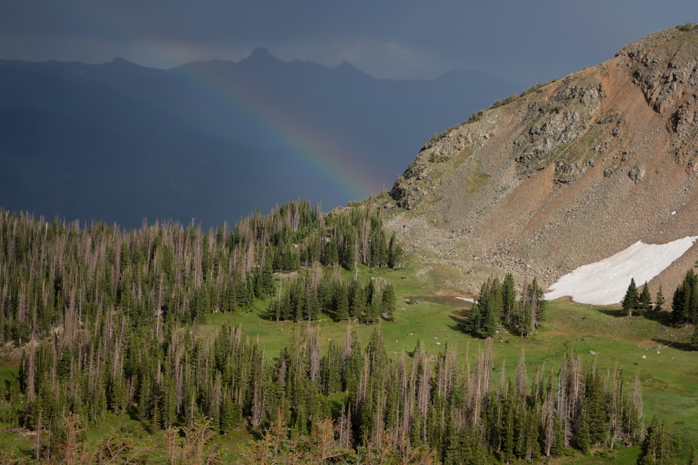 un arco iris en el cielo sobre una cadena montañosa