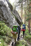 a group of people with backpacks walking up a trail