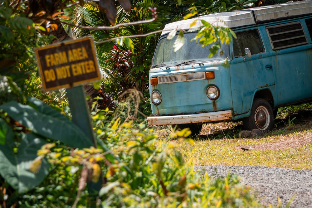 an old blue van is parked in the grass