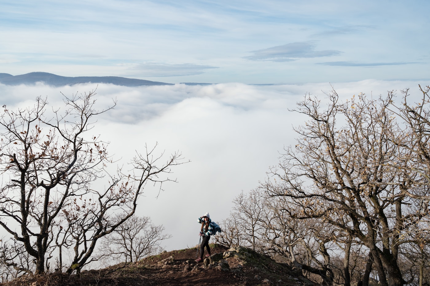Two people standing on a mountain peak overlooking the landscape