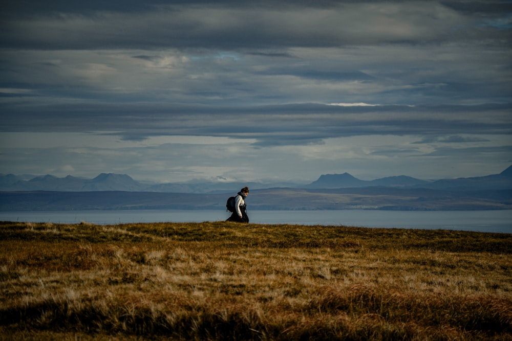 a man sitting on top of a grass covered field
