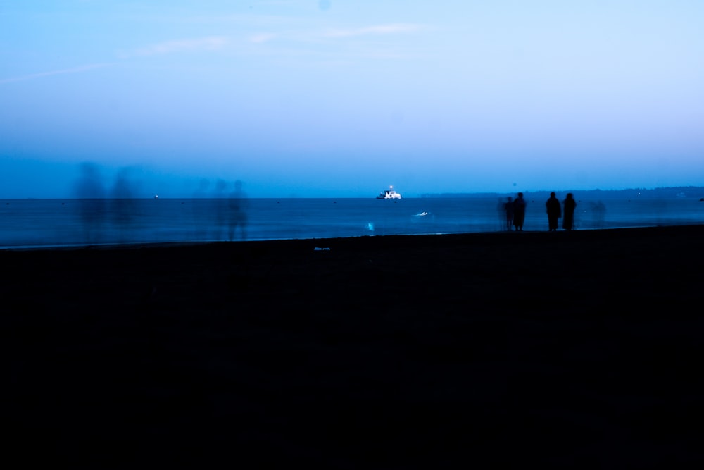 a group of people standing on top of a beach