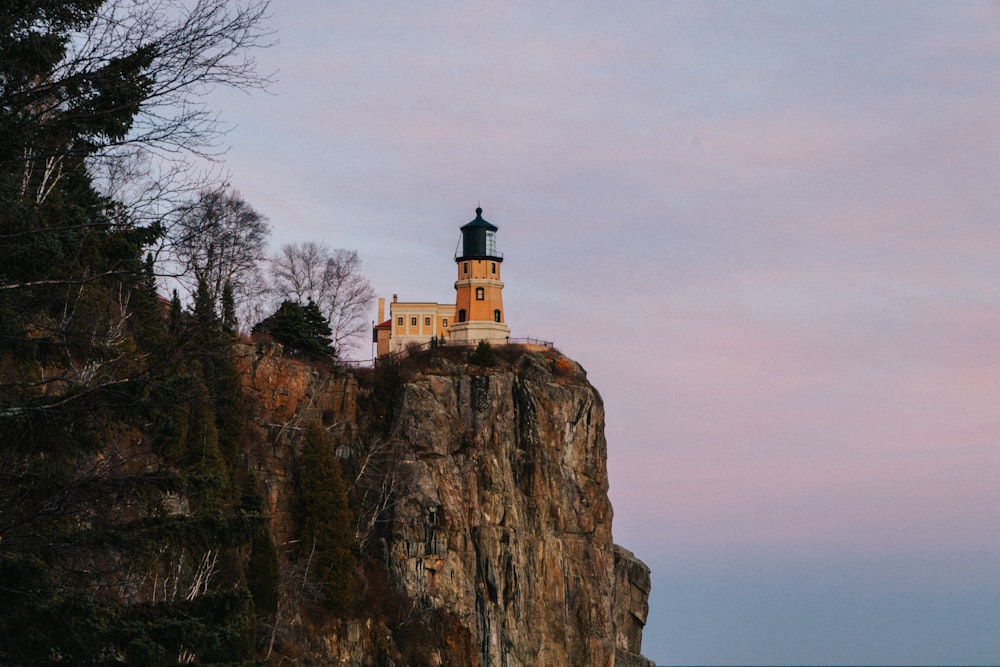 a lighthouse on top of a cliff near the ocean