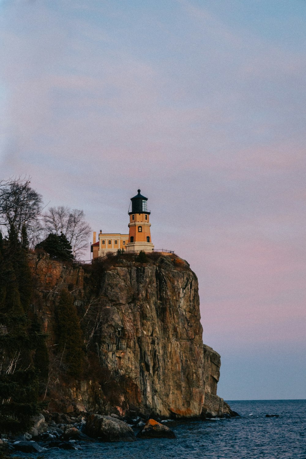 a lighthouse on top of a rock in the ocean