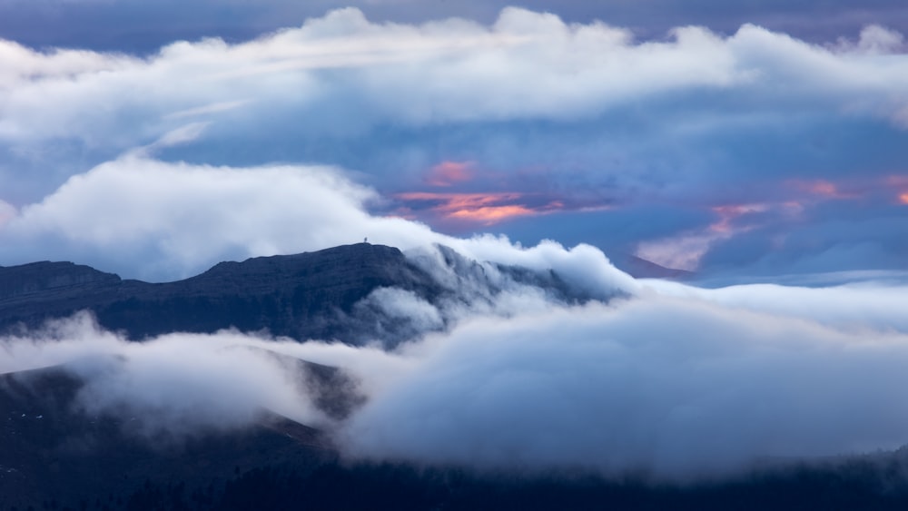 a view of a mountain covered in clouds