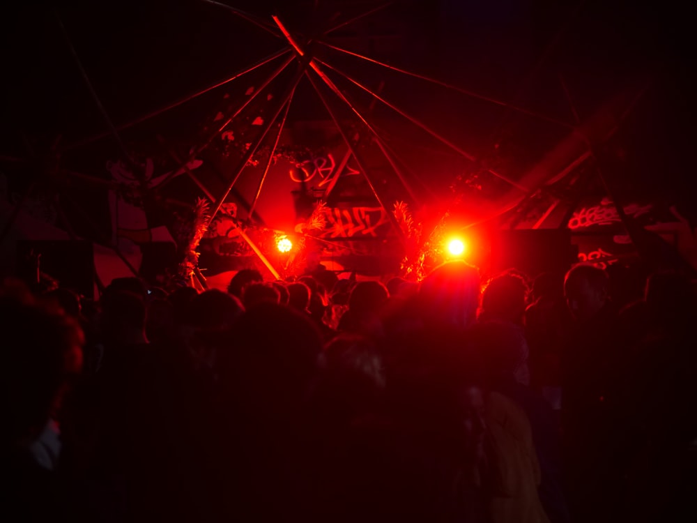 a crowd of people standing around a stage at night