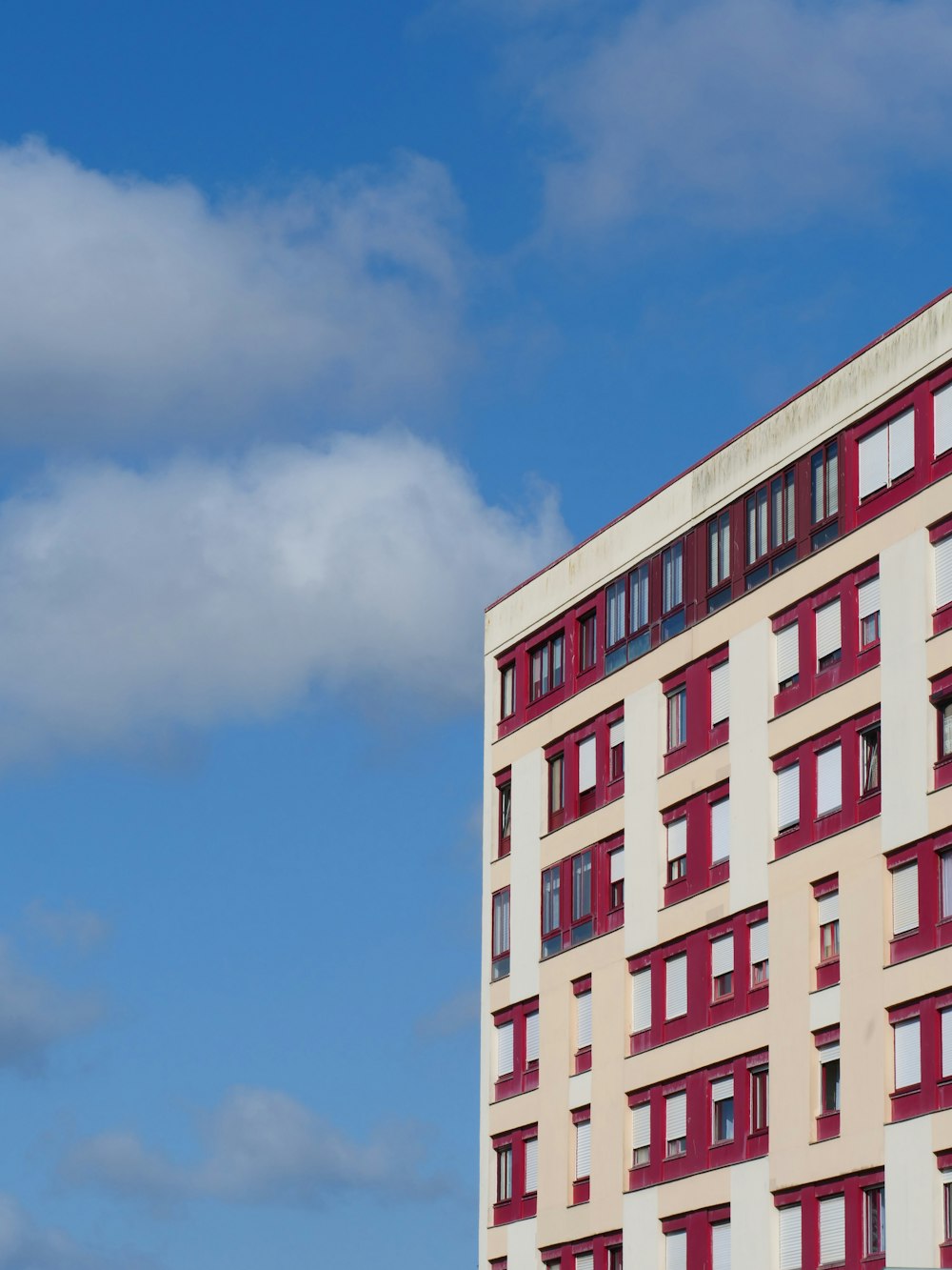 a tall red and white building with red windows