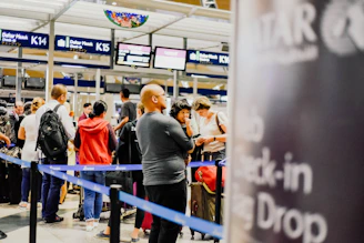 a group of people standing in a line at an airport