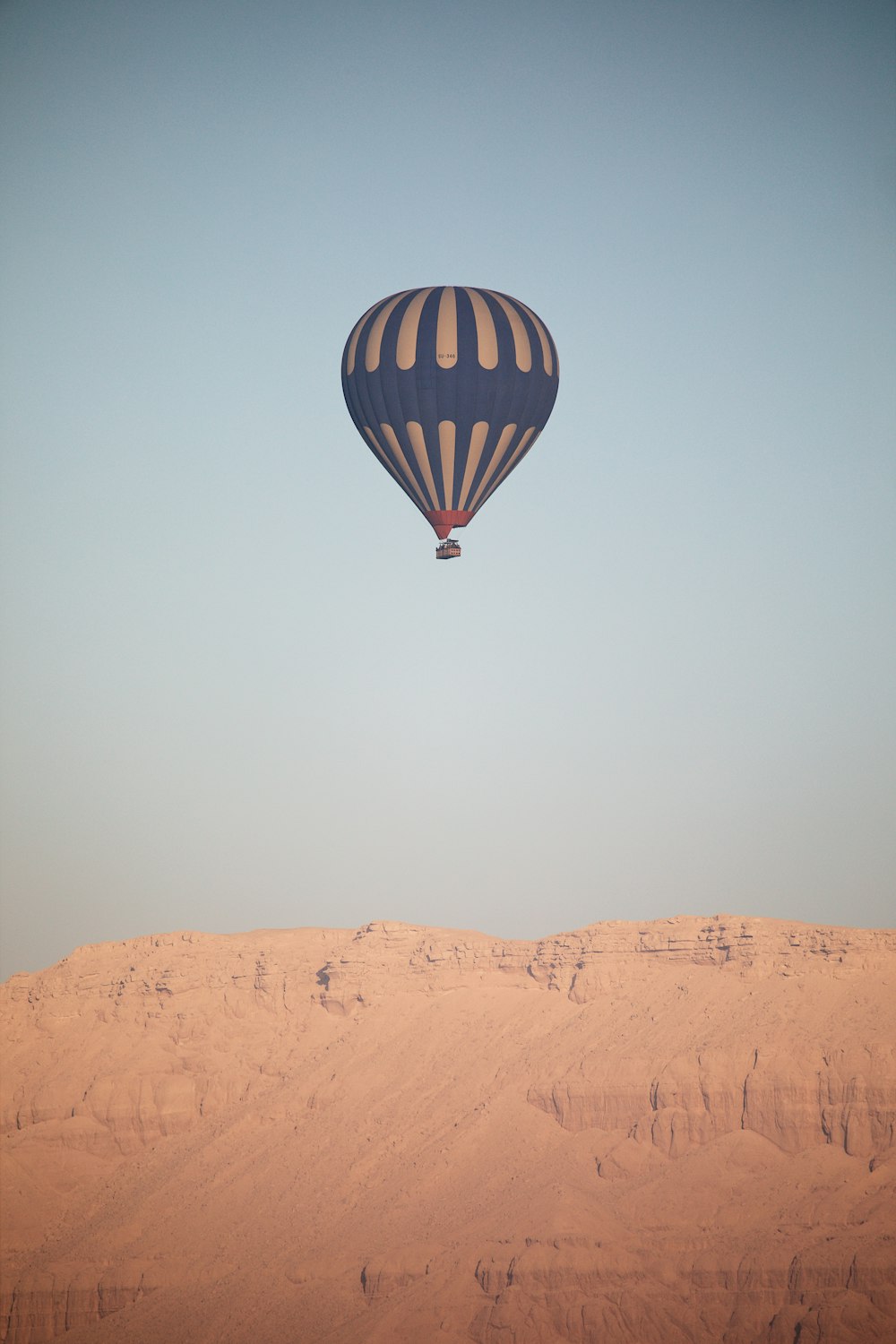 a hot air balloon flying over a desert landscape