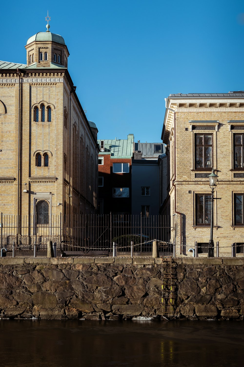 un grande edificio in mattoni accanto a uno specchio d'acqua