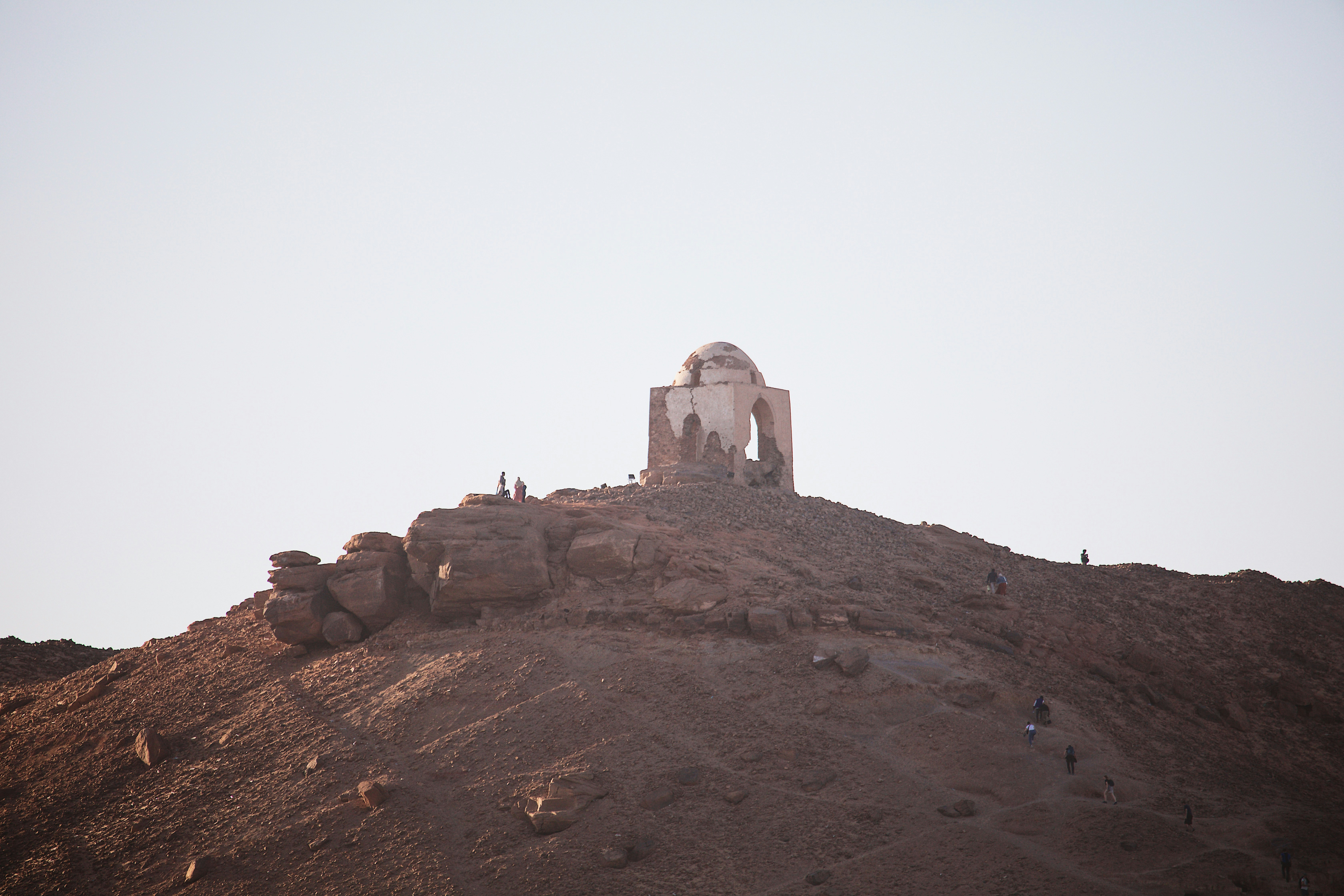 a small building on top of a rocky hill, 
