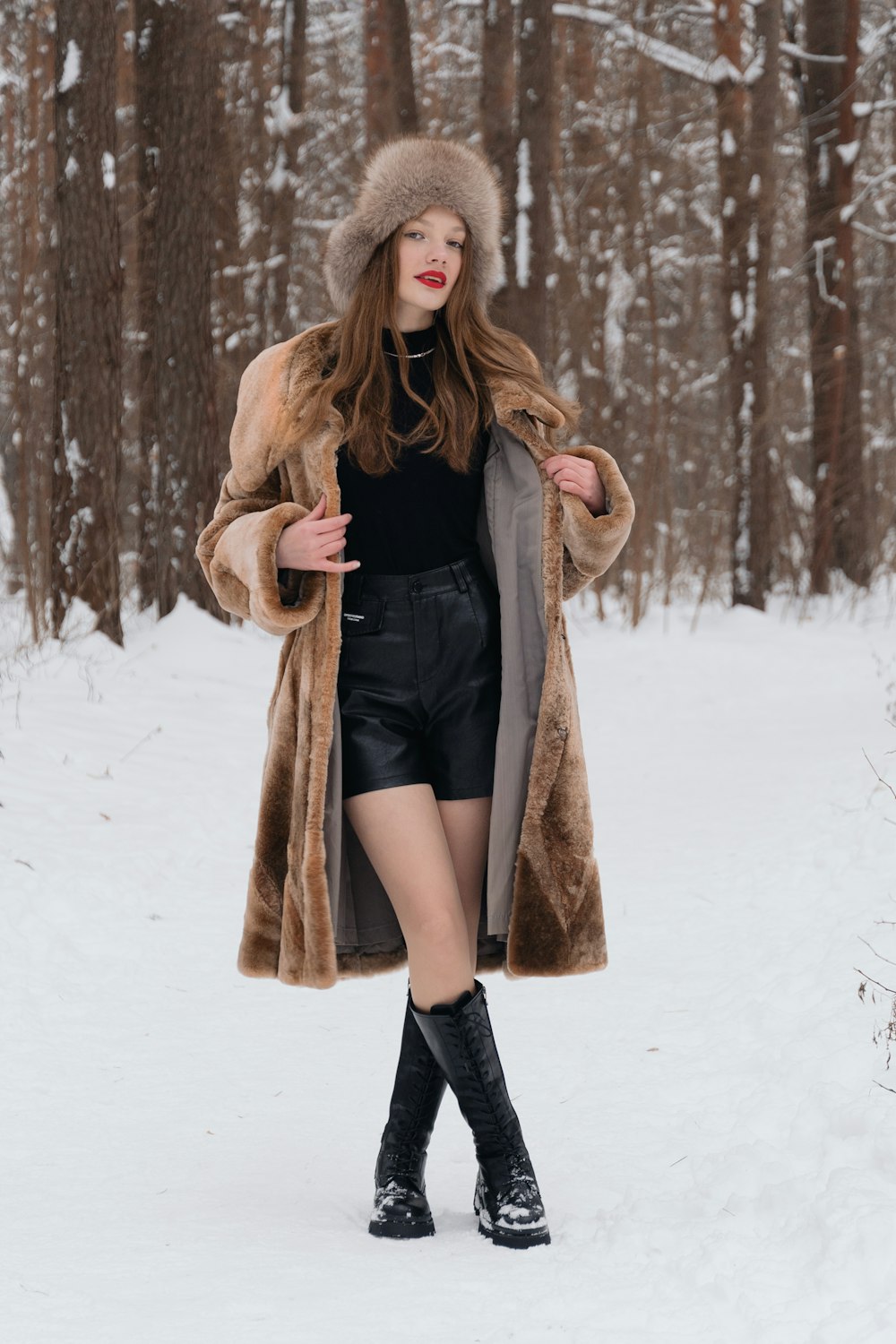 a woman in a fur hat and coat in the snow