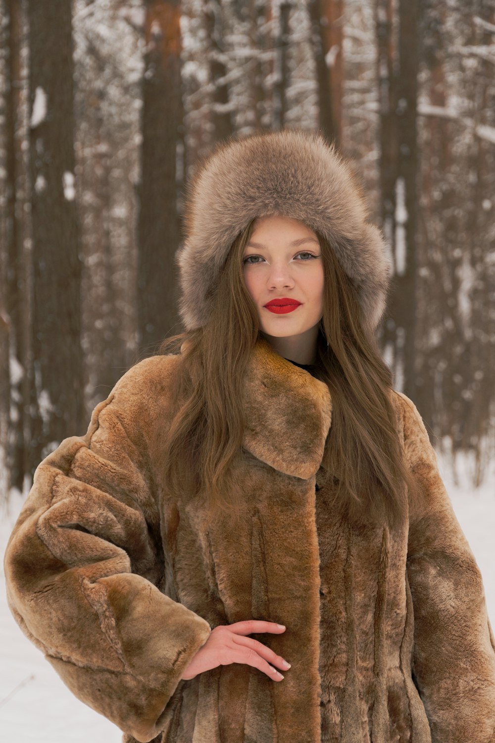 a woman in a fur coat standing in the snow