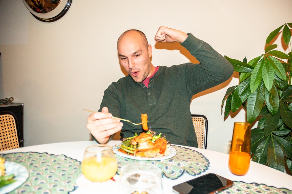 a man sitting at a table with a plate of food