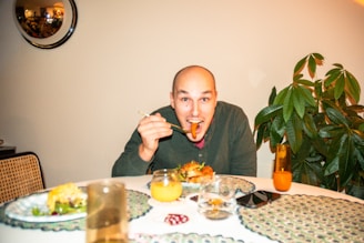 a man sitting at a table with a plate of food in front of him