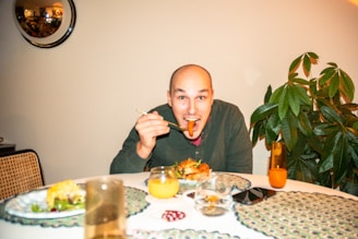 a man sitting at a table with a plate of food in front of him