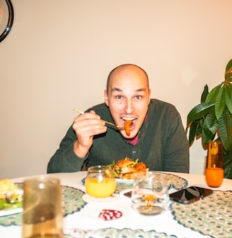 a man sitting at a table with a plate of food in front of him