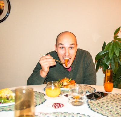 a man sitting at a table with a plate of food in front of him