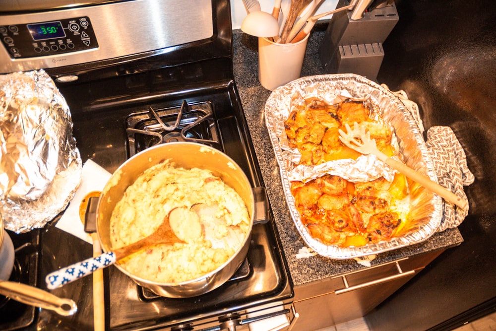 two pans of food sitting on top of a stove