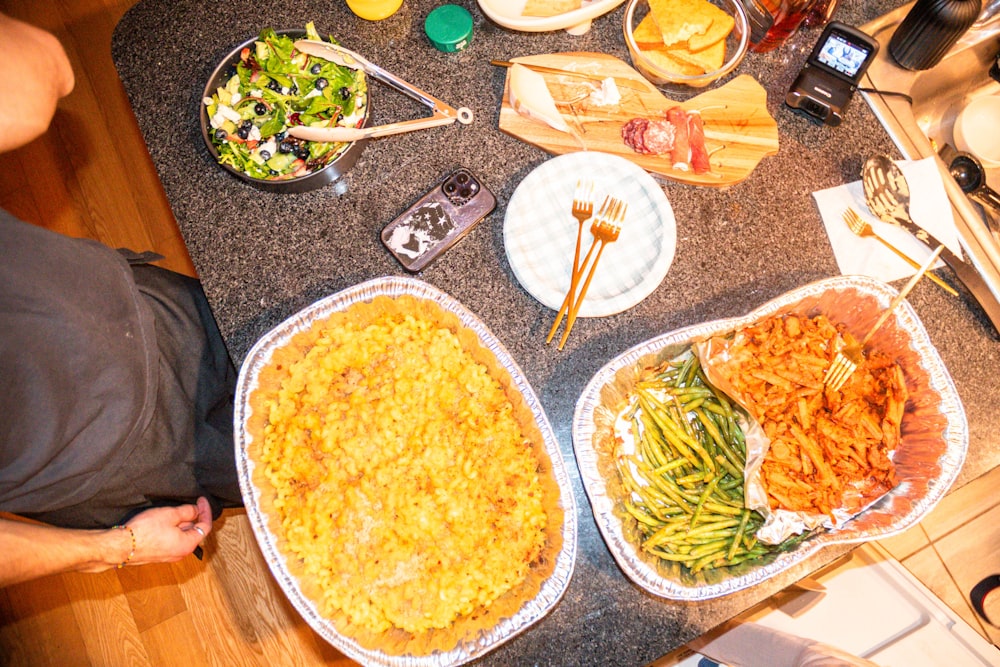 食べ物でいっぱいのテーブルの前に立つ男