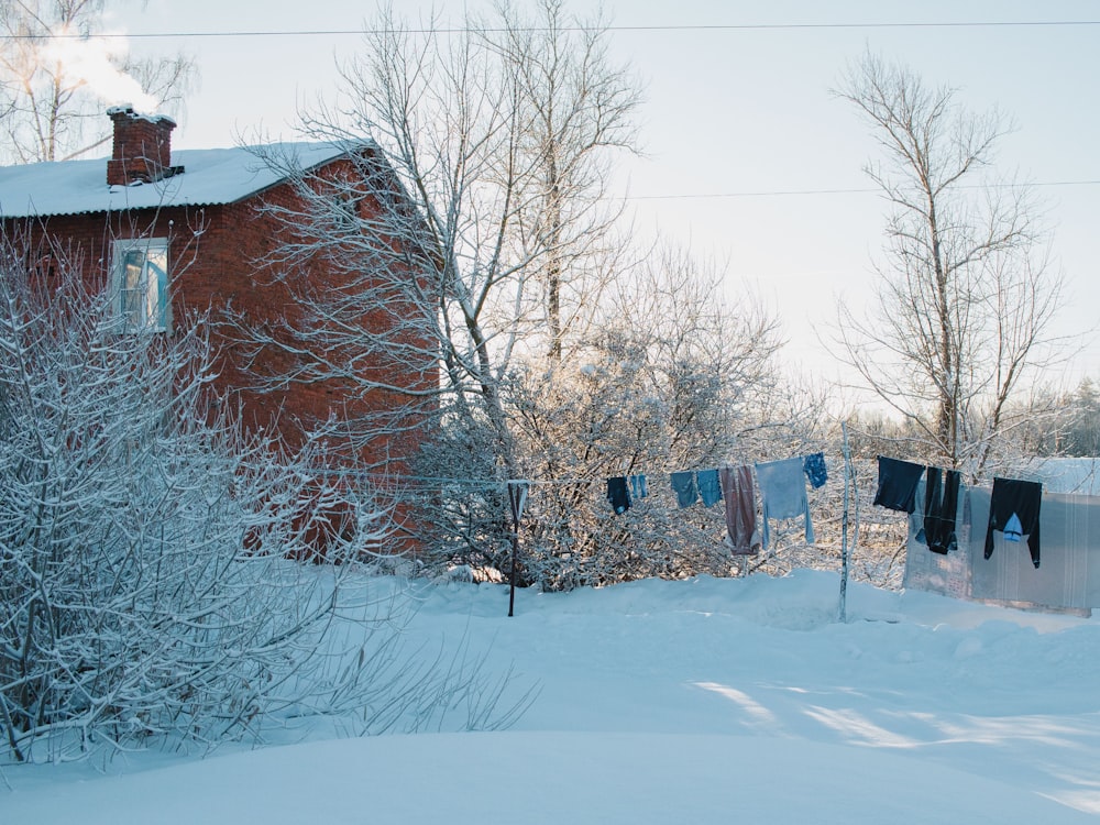 a red house with clothes hanging out to dry in the snow