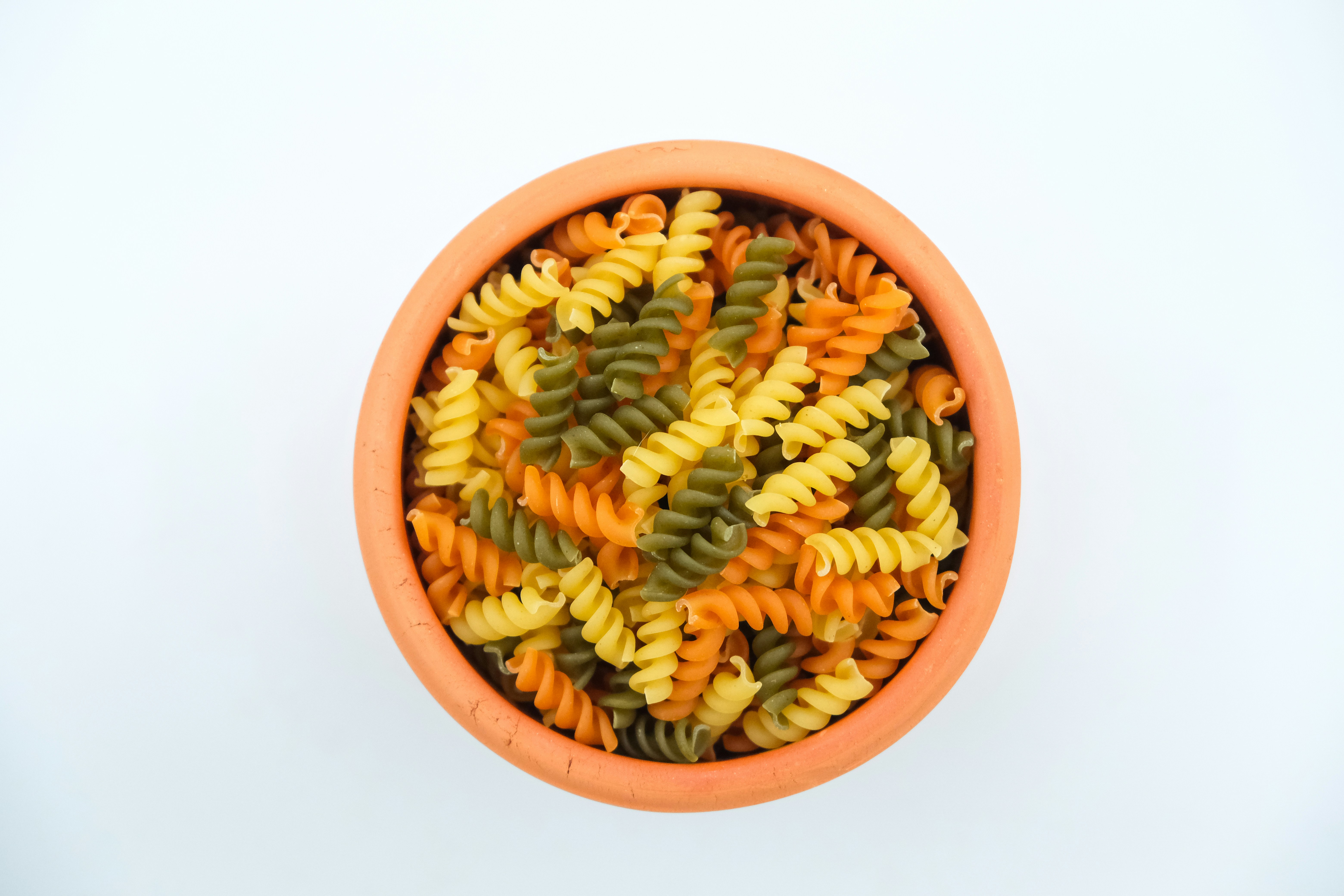 a bowl filled with different colored pasta noodles
