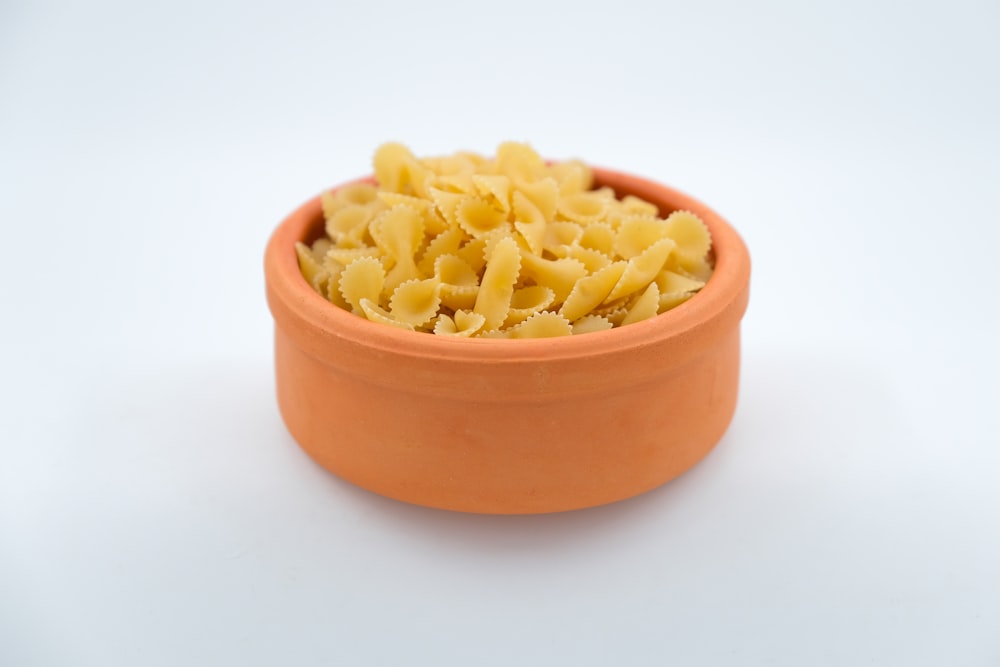 a bowl filled with pasta sitting on top of a white table