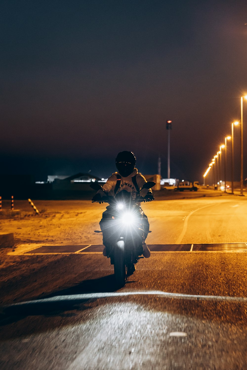 a man riding a motorcycle down a street at night