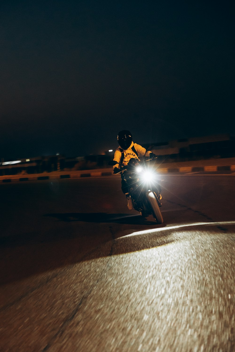 a man riding a motorcycle down a street at night