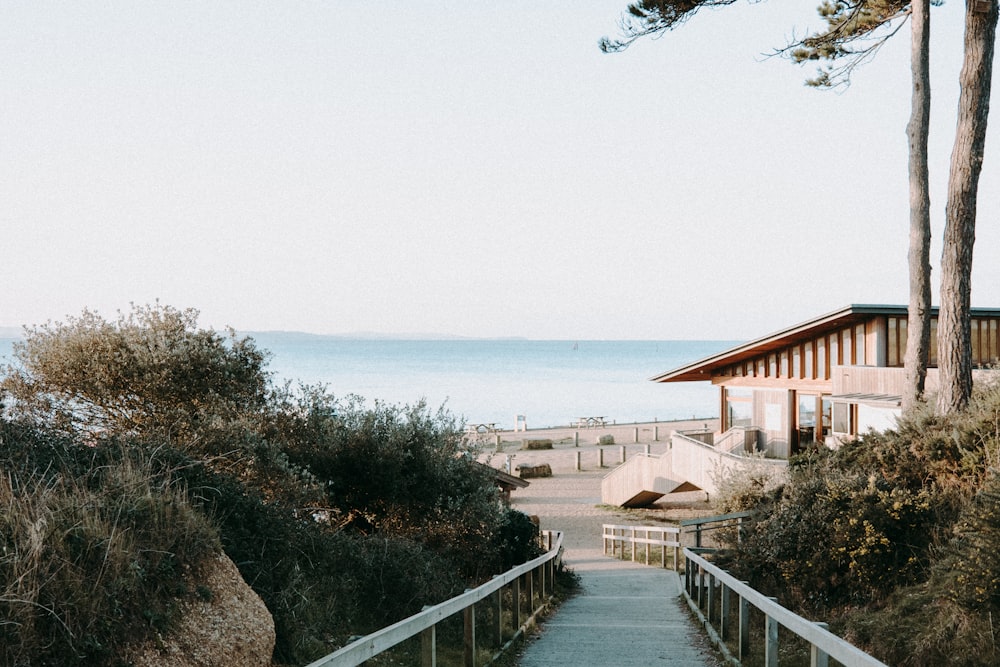 a walkway leading to a beach with a building in the background