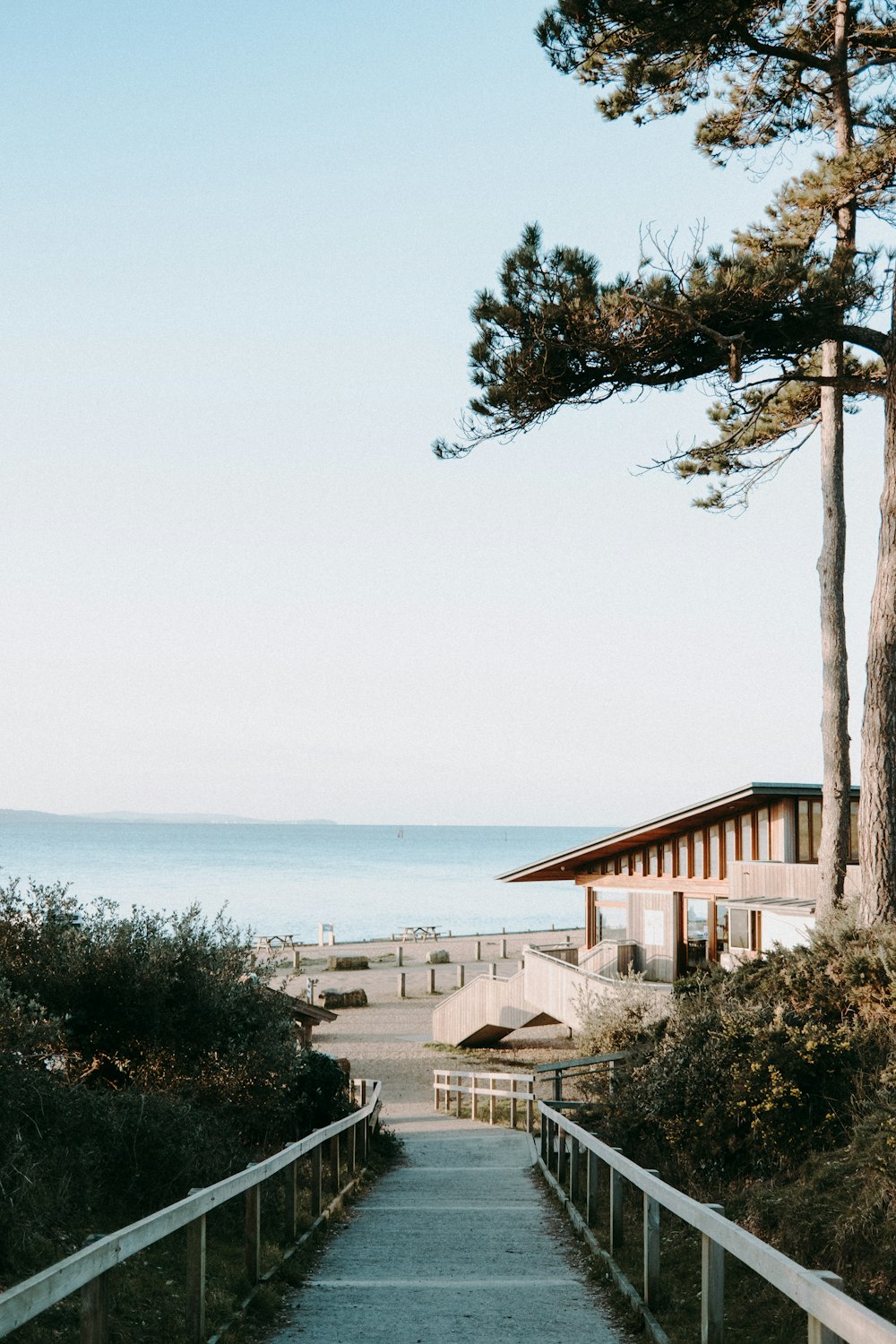 a walkway leading to a beach with a building in the background