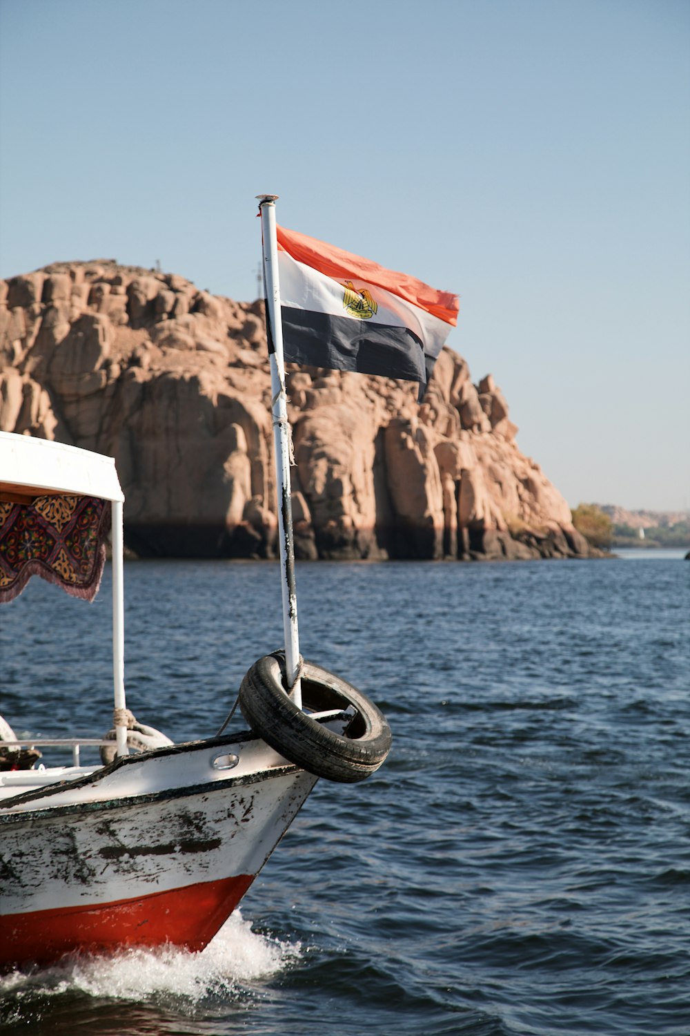 a boat in the water with a flag on top of it