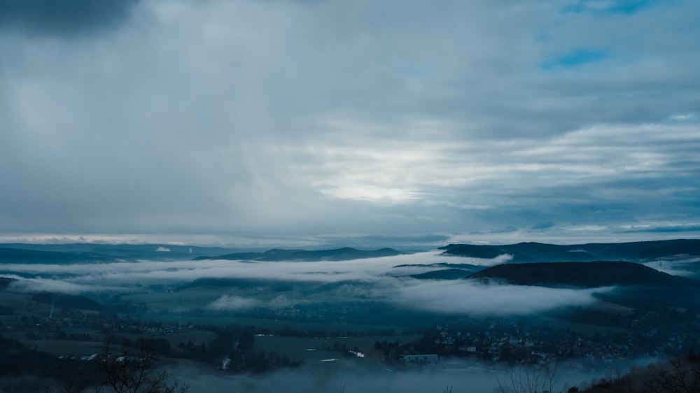 a view of a valley covered in clouds