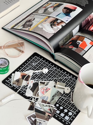 an open book sitting on top of a table next to a cup of coffee