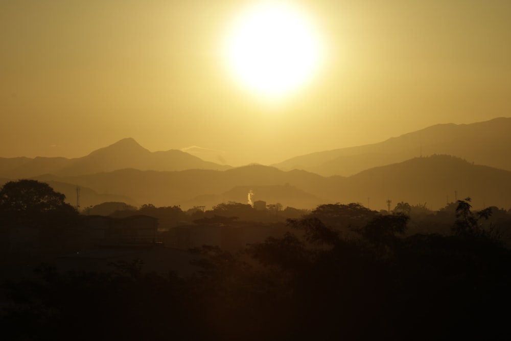 the sun is setting over a mountain range